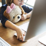 little girl using computer for online testing