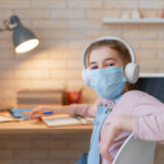 featured image of girl wearing face mask using a computer