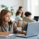 Mädchen benutzt den Computer, um die Ergebnisse der Online-Beurteilung zu sehen