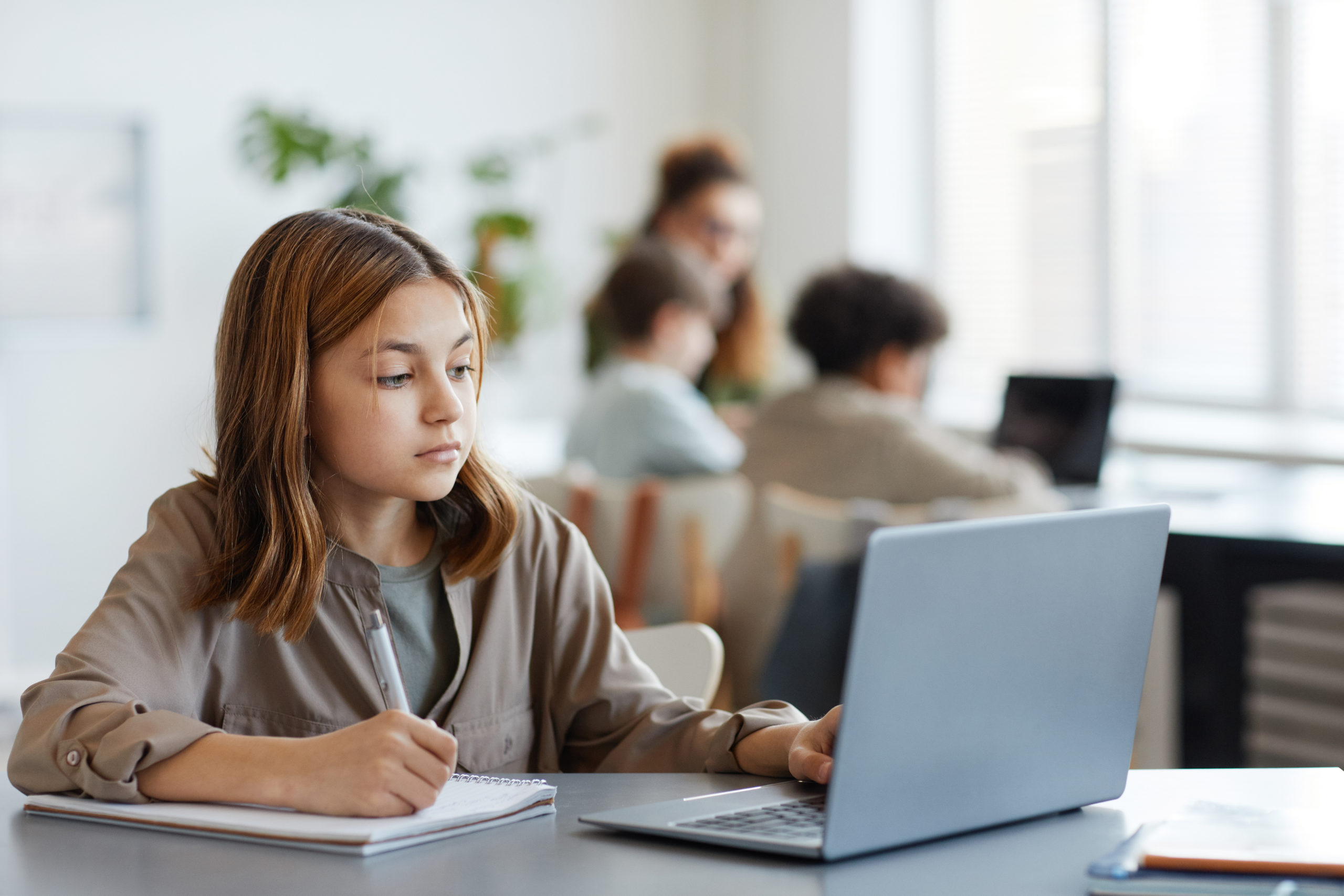 オンライン評価の結果を見るためにコンピュータを使う少女
