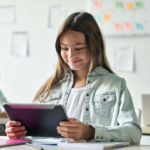 Image en vedette d'une écolière utilisant une tablette pour développer des compétences d'apprentissage socio-affectif.