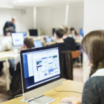 Imagen destacada de un estudiante en un ordenador del laboratorio realizando una evaluación que garantiza la validez del examen.