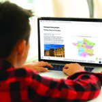 タオのデジタル評価プラットフォームが表示されたノートパソコンを使用する少年。