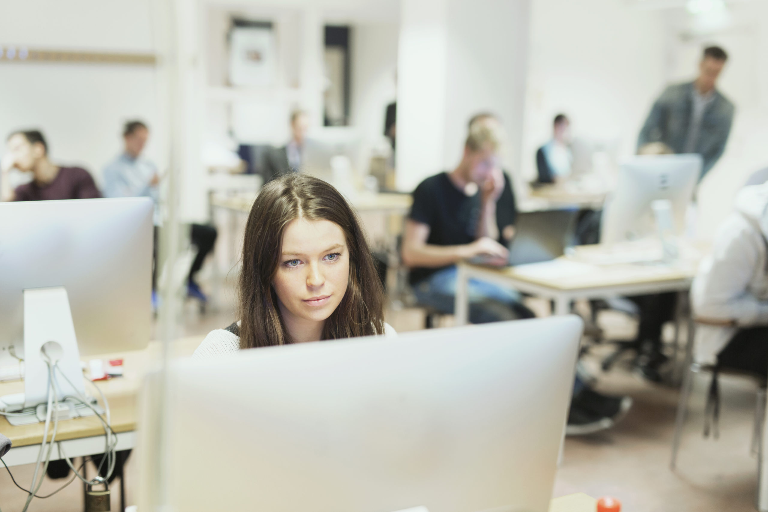 Femme utilisant un ordinateur dans un laboratoire informatique montrant l'utilisation d'outils d'évaluation de l'enseignement supérieur dans la salle de classe.