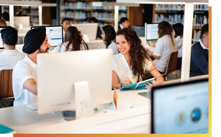 Multicultural adults sitting in computer class