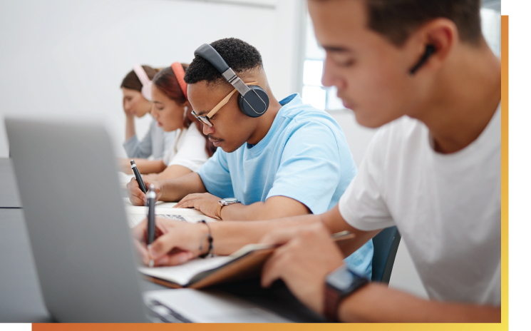 Side view of students in headphones working at computers