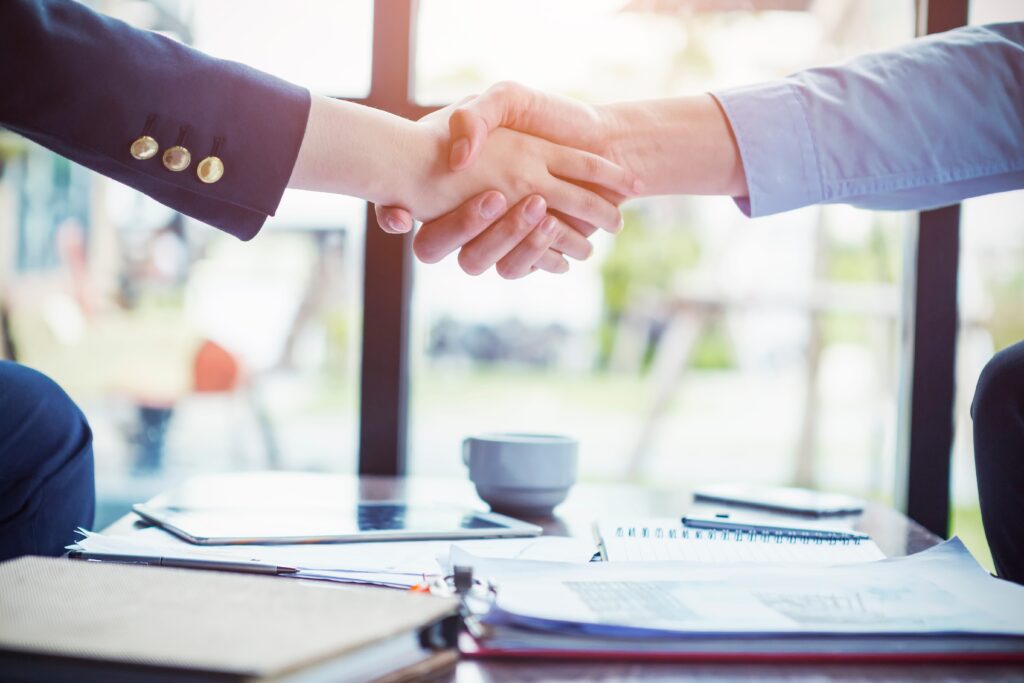 Close up of view of a handshake between two business people wearing suits.