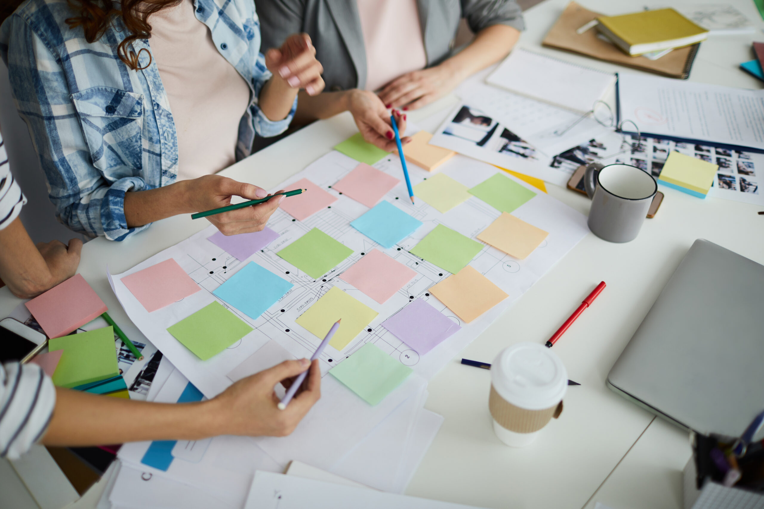 Group of three people sitting at a desk planning a product roadmap for testing technology.