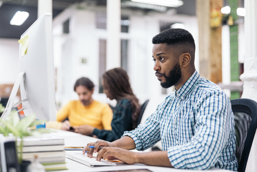 Jeune homme utilisant un ordinateur pour une évaluation de la pensée critique.
