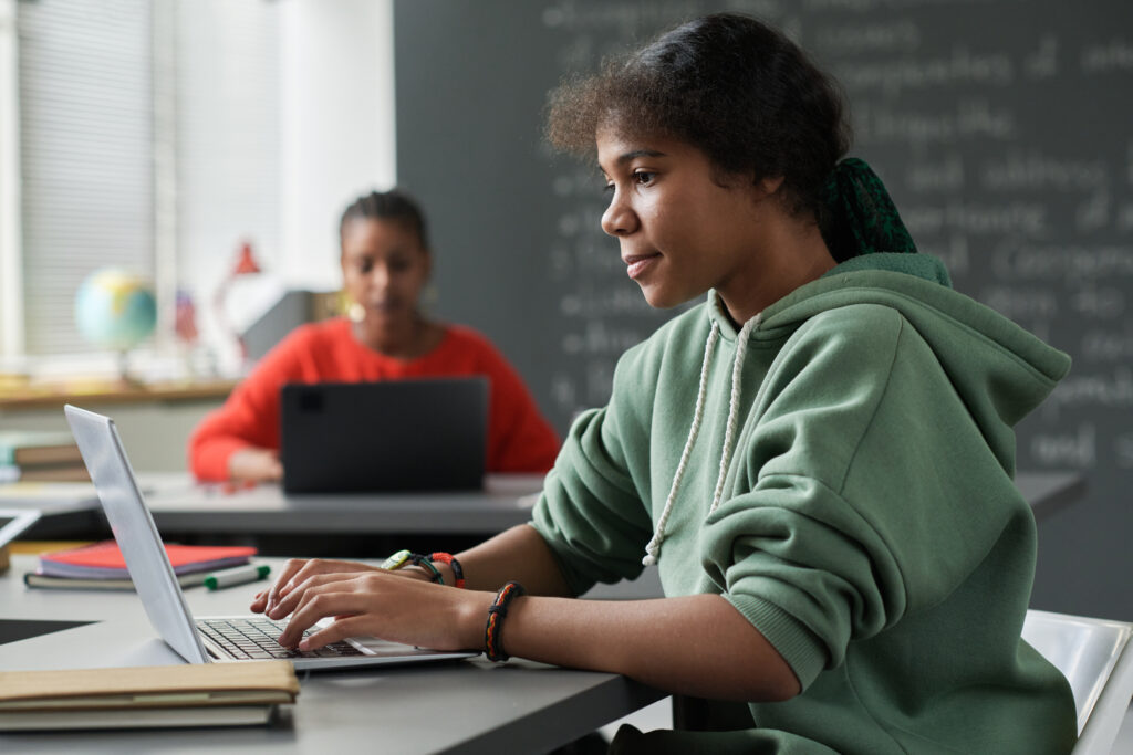 社会的情動の学習／SELアセスメントのためにノートパソコンを使用する授業中の女子生徒。