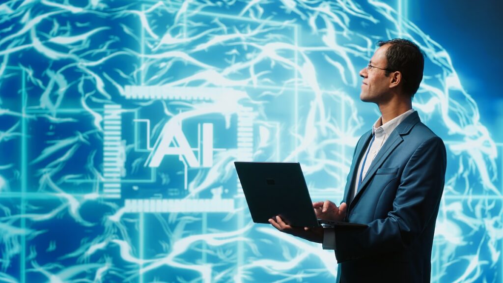 Man standing in front of abstract hologram code holding a laptop demonstrating the concept of the ethical use of AI in education