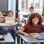 Portrait d'élèves du primaire assis à leur pupitre, s'apprêtant à passer un contrôle dans une salle de classe moderne de l'enseignement primaire et secondaire
