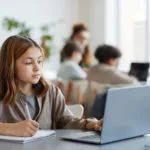 girl using computer to see online assessment results