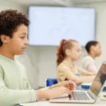 授業でエデュケーションテクノロジーを使う少年像