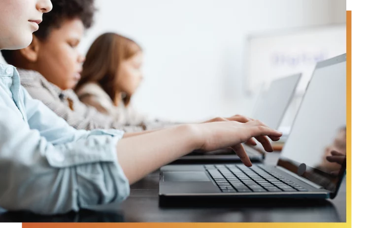 Side view of three children using laptops