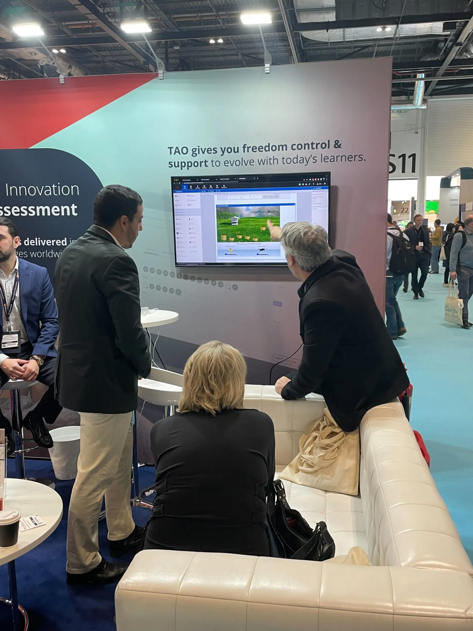 In the TAO booth viewing a demo at Bett UK, showing TAO's test accessibility principles and accessible exam platform.