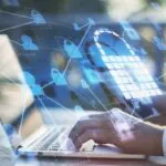 Gros plan sur les mains tapant sur un ordinateur portable. Superposée à la photo, une toile de connectivité de données relie un cadenas transparent, illustrant le concept de souveraineté des données critiques dans l'évaluation éducative.