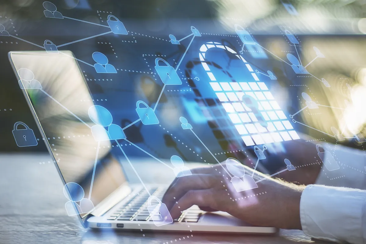 Close up side view of hands typing on a laptop. Overlaid on top of the photo is a data connectivity web that connects transparent lock, demonstrating the concept of critical data sovereignty in educational assessment.